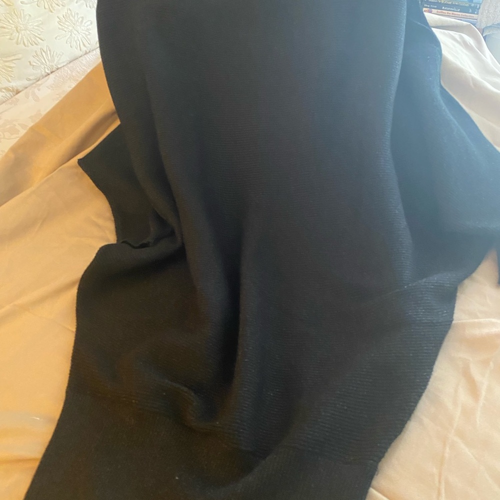 Black dress -looser on top and snug orotund the bottom.